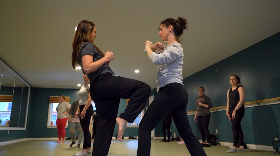 Participants practice self-defense techniques with focus and determination. 
